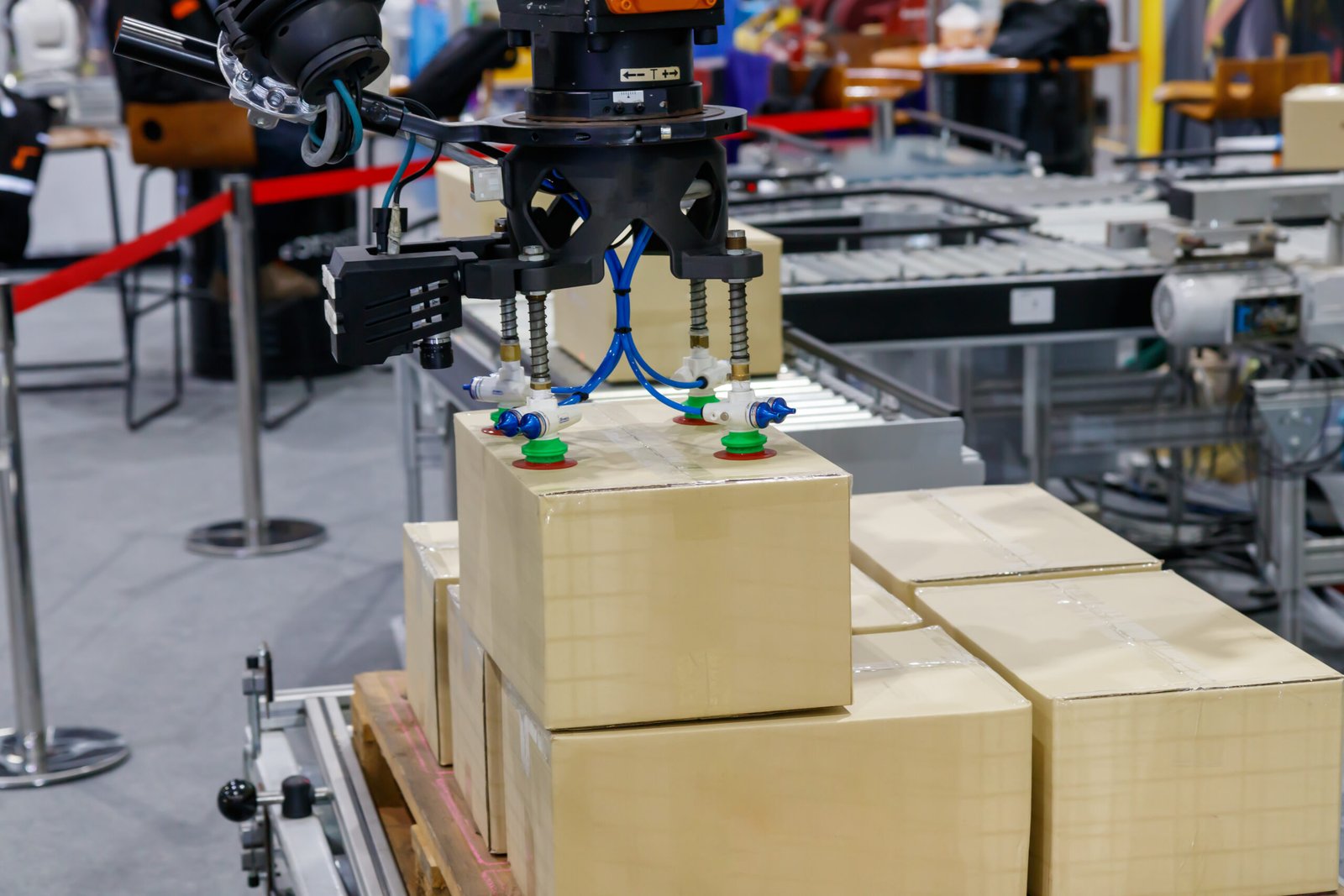 Cabezal robotizado con ventosas manipulando cajas sobre una línea
